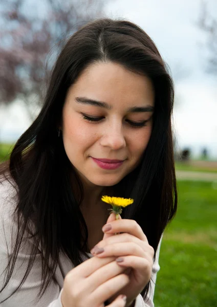 Porträtt av en glad vackra unga kvinna som håller en blomma — Stockfoto