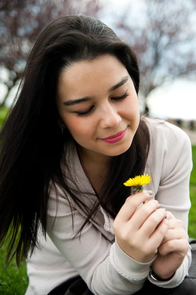 Porträtt av en glad vackra unga kvinna som håller en blomma — Stockfoto