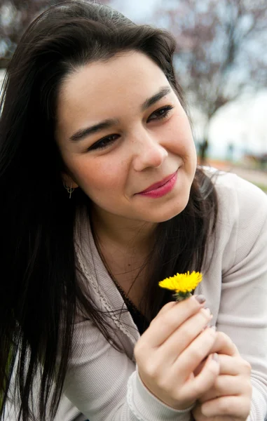 Portrait d'une belle jeune femme heureuse tenant une fleur — Photo