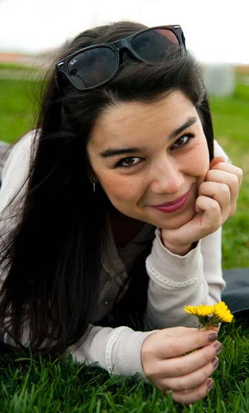Retrato de uma jovem mulher bonita feliz segurando uma flor — Fotografia de Stock