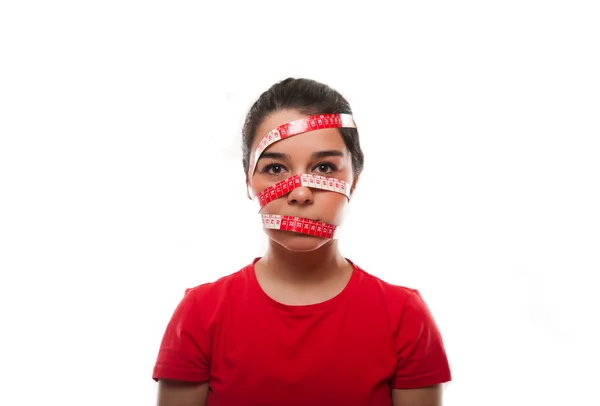 Jonge vrouwelijke gezicht bedekt met een meetlint — Stockfoto