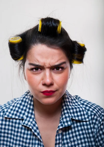 Ung kvinna med gula rullar i håret — Stockfoto