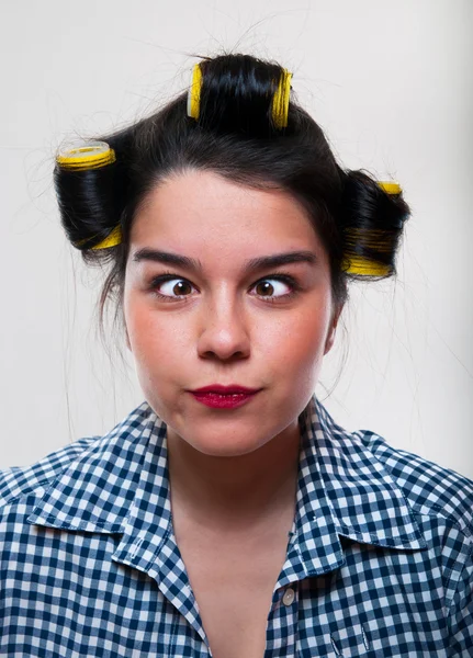 Ung kvinna med gula rullar i håret — Stockfoto