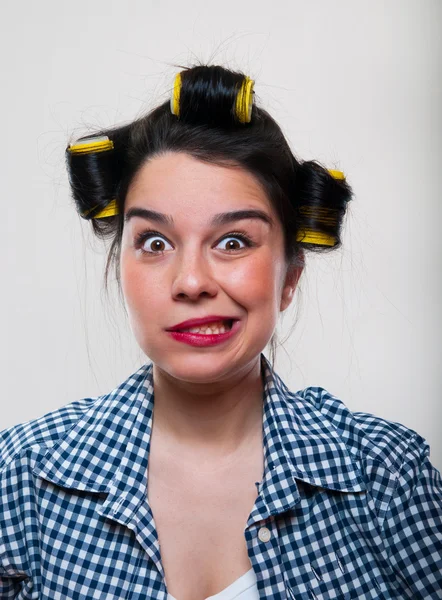 Jonge vrouw met gele rollen in het haar — Stockfoto