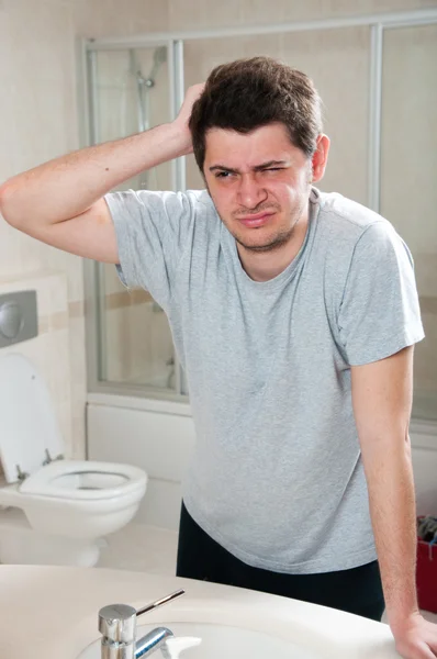 Man looking himself in front of mirror with sleepy eyes — Stock Photo, Image
