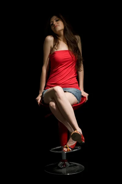 Bella giovane donna seduta su uno sgabello — Foto Stock