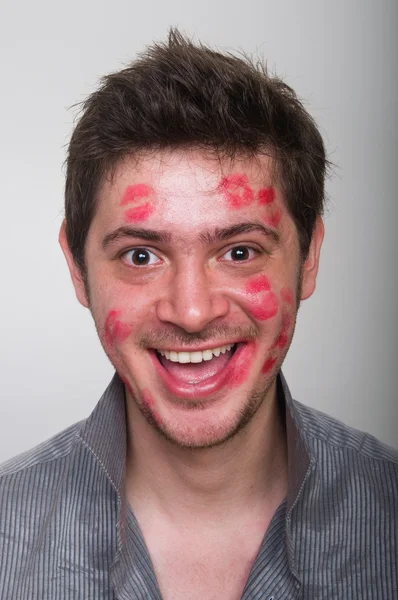 Portrait of a handsome guy with a face full of kisses — Stock Photo, Image