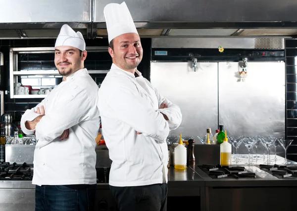 Két szakácsok, mosolyog, és a gazdaság edényfelszereléssel portréja Stock Fotó