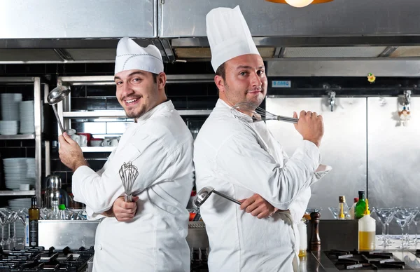 Két szakácsok, mosolyog, és a gazdaság edényfelszereléssel portréja Stock Kép