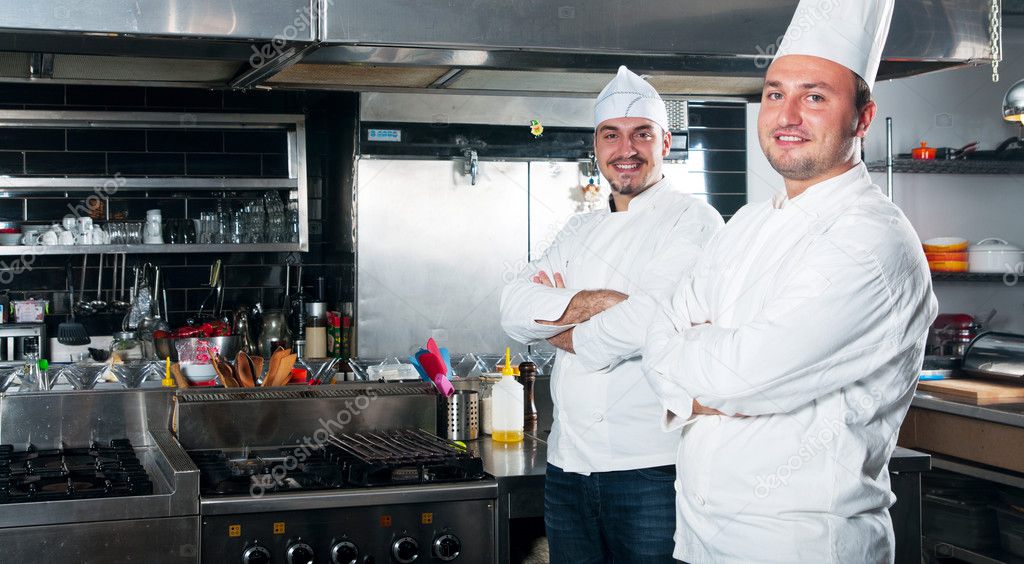 Portrait of two chefs smiling and holding kitchen utensil Stock Photo ...