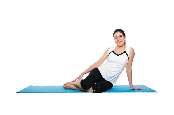 Bela jovem fêmea exercitando em um matt azul — Fotografia de Stock