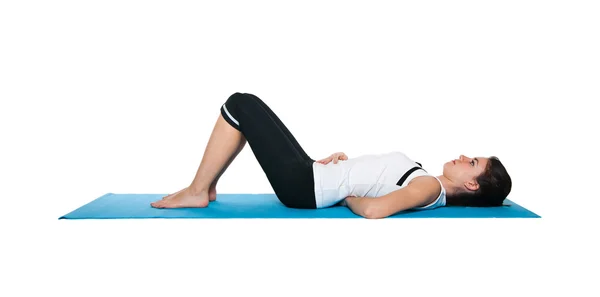 stock image Beautiful young female exercising on a blue matt