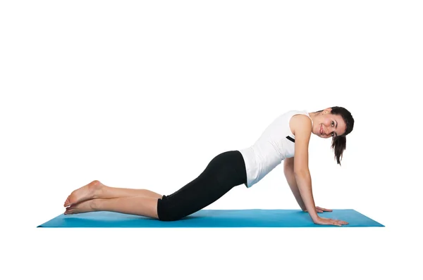 Beautiful young female exercising on a blue matt — Stock Photo, Image