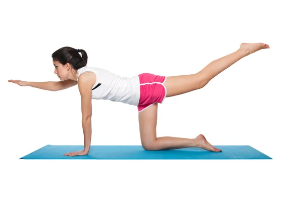 stock image Beautiful young female exercising on a blue matt