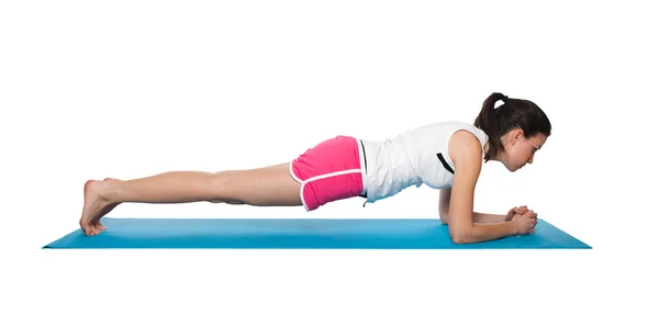 Schöne junge Frau beim Training auf einem blau-matten — Stockfoto
