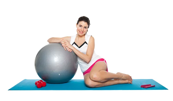 Beautiful young female exercising on a blue matt — Stock Photo, Image