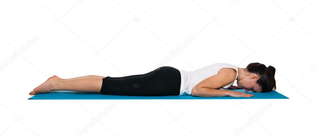 Beautiful young female exercising on a blue matt