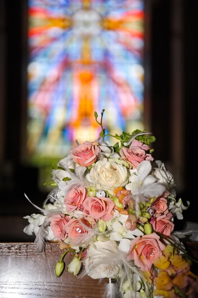 Wedding bouquet in front of stained glass — Stock Photo, Image