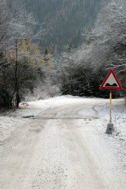 karlı dağ yolunda yol işareti