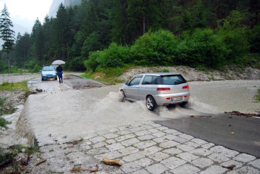 Car crossing a road flooded clipart