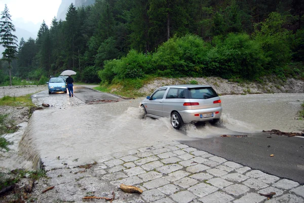 stock image Car crossing a road flooded