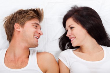 Young lovely couple lying in a bed