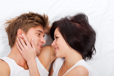 Young lovely couple lying in a bed