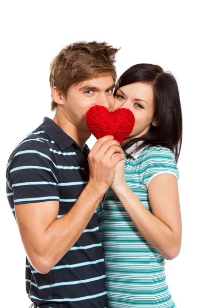 Joven pareja de amor sosteniendo corazón rojo — Foto de Stock