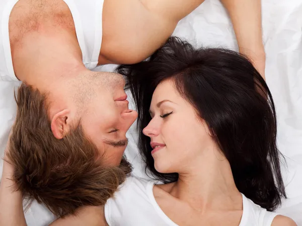 Young lovely couple lying in a bed — Stock Photo, Image