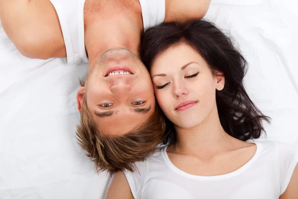 Joven pareja encantadora acostada en una cama —  Fotos de Stock