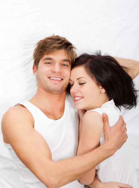 Jeune beau couple couché dans un lit — Photo