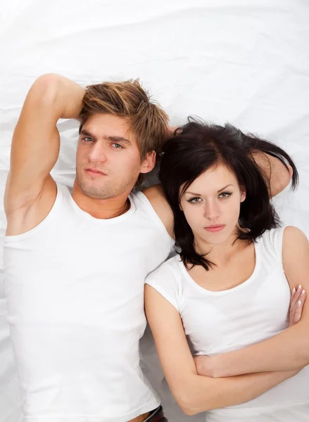Rozrušený mladý pár v posteli — Stock fotografie