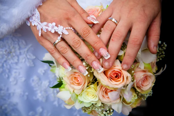 Hands of a newly-married couple Stock Picture