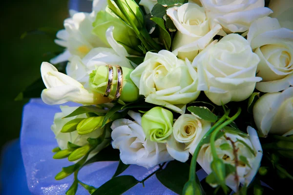 Vigselringar på bröllop blommor. — Stockfoto