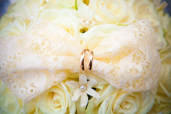 Snubní prsteny na bílé svatební květiny. — Stock fotografie