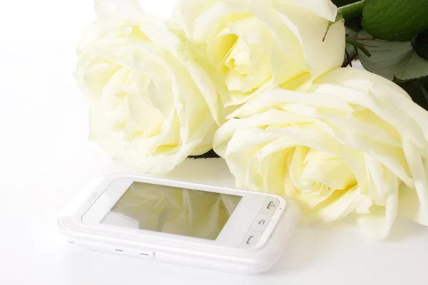 Białe róże i telefon komórkowy — Zdjęcie stockowe