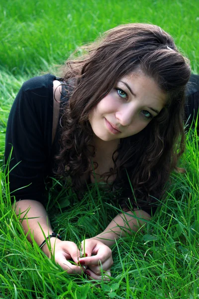 Tiener op een groen gras. — Stockfoto