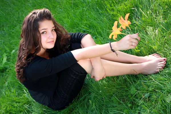 Meisje de tiener over een bloem. — Stockfoto