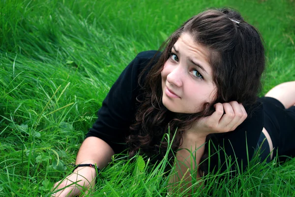 Meisje op een groen gras. — Stockfoto