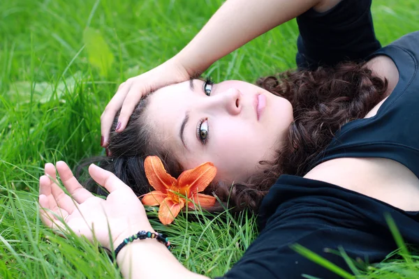 La muchacha el adolescente sobre la flor . — Foto de Stock