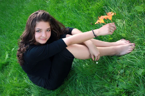 Meisje over een bloem, op een gras. — Stockfoto