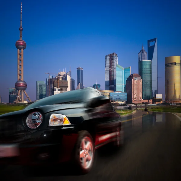 Carro rápido que se move a partir de uma cidade moderna. o fundo com o marco da China shanghai . — Fotografia de Stock