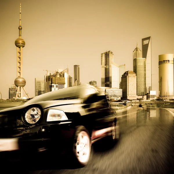 Быстрая машина, движущаяся из современного города на фоне достопримечательностей Китая . — стоковое фото