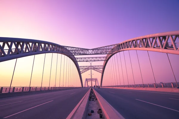 Camion che corre attraverso un ponte al tramonto, sfocatura del movimento . — Foto Stock