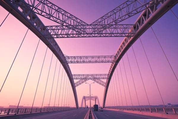 Teherautó gyorshajtás keresztül egy híd, a naplemente, motion blur. — Stock Fotó