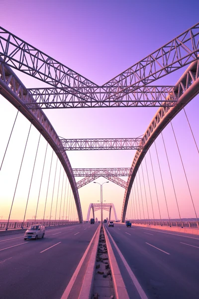 Caminhão acelerando através de uma ponte ao pôr do sol, borrão de movimento . — Fotografia de Stock