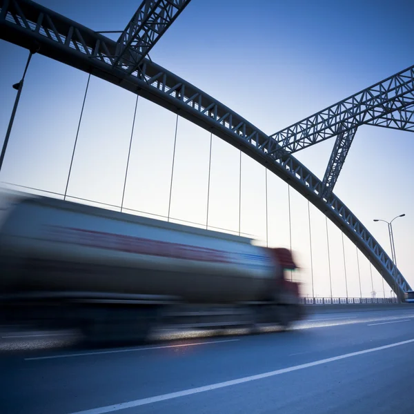 Truck speeding through a bridge at sunset,motion blur. — Stock Photo, Image