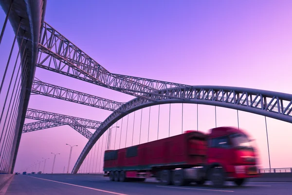 Truck speeding through a bridge at sunset,motion blur. — Stock Photo, Image