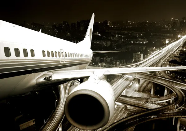 A repülőgép felszáll a város éj-től. — Stock Fotó