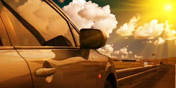 Bilen på vägen med bakgrund av äng. — Stockfoto